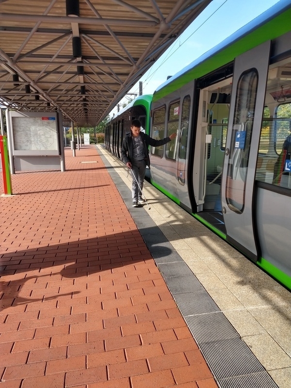 Ein Jugendlicher steht vor einer Bahn im Bahnhof.