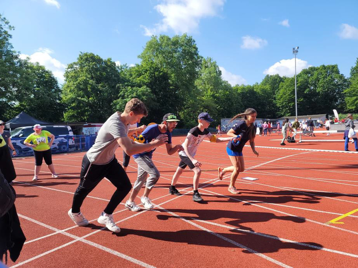 Zwei Schüler starten zum 100m Sprint mit ihren Begleitläufern
