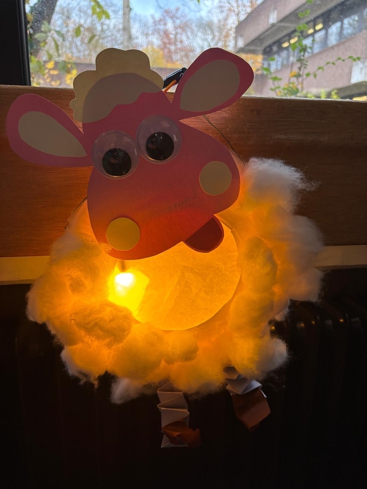 Schaun das Schaf als selbstgebastelte, leuchtende Laterne vor einem Fenster.