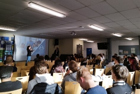 Eine Dame der PEN World steht auf der Bühne und hält vor Auszubildenden einen Vortrag