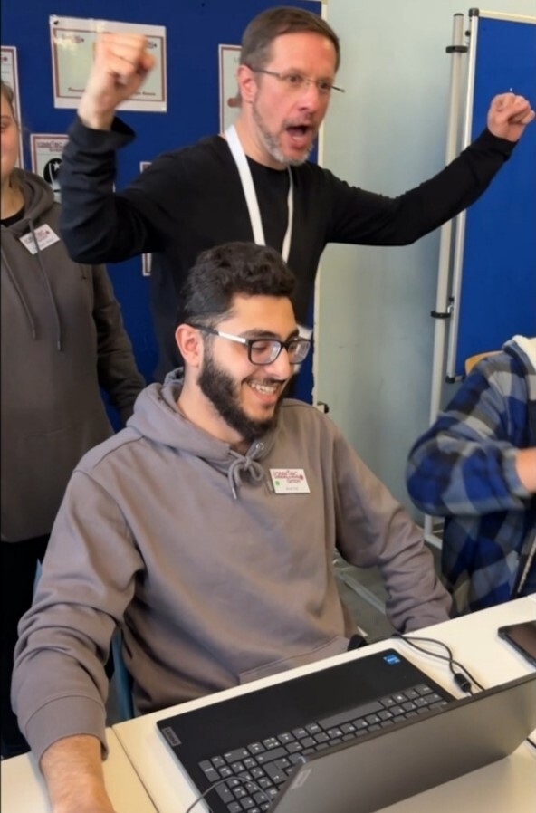 Ein Ausbilder und ein Auszubildender freuen sich über gute Geschäfte auf der Messe.