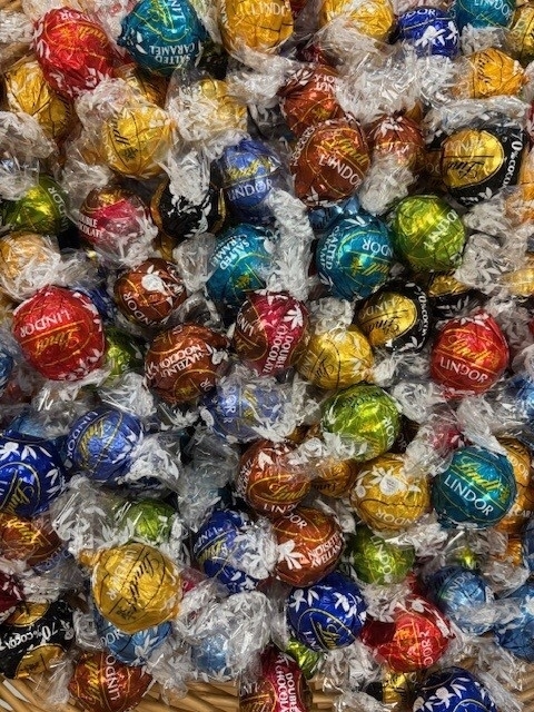 Ein Korb, gefüllt mit vielen bunten Schokokugeln.