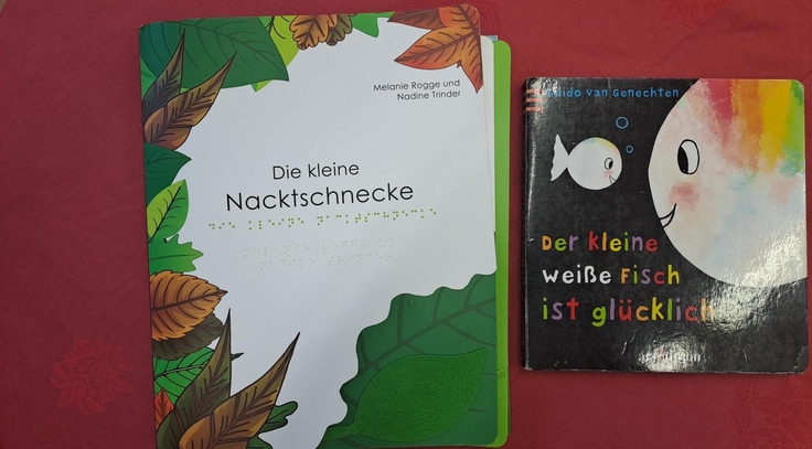 Auf dem Foto sieht man das Fühlbuch „Die kleine Nacktschnecke“ und das kontrastreiche Bilderbuch „Der kleine weiße Fisch ist glücklich“.
