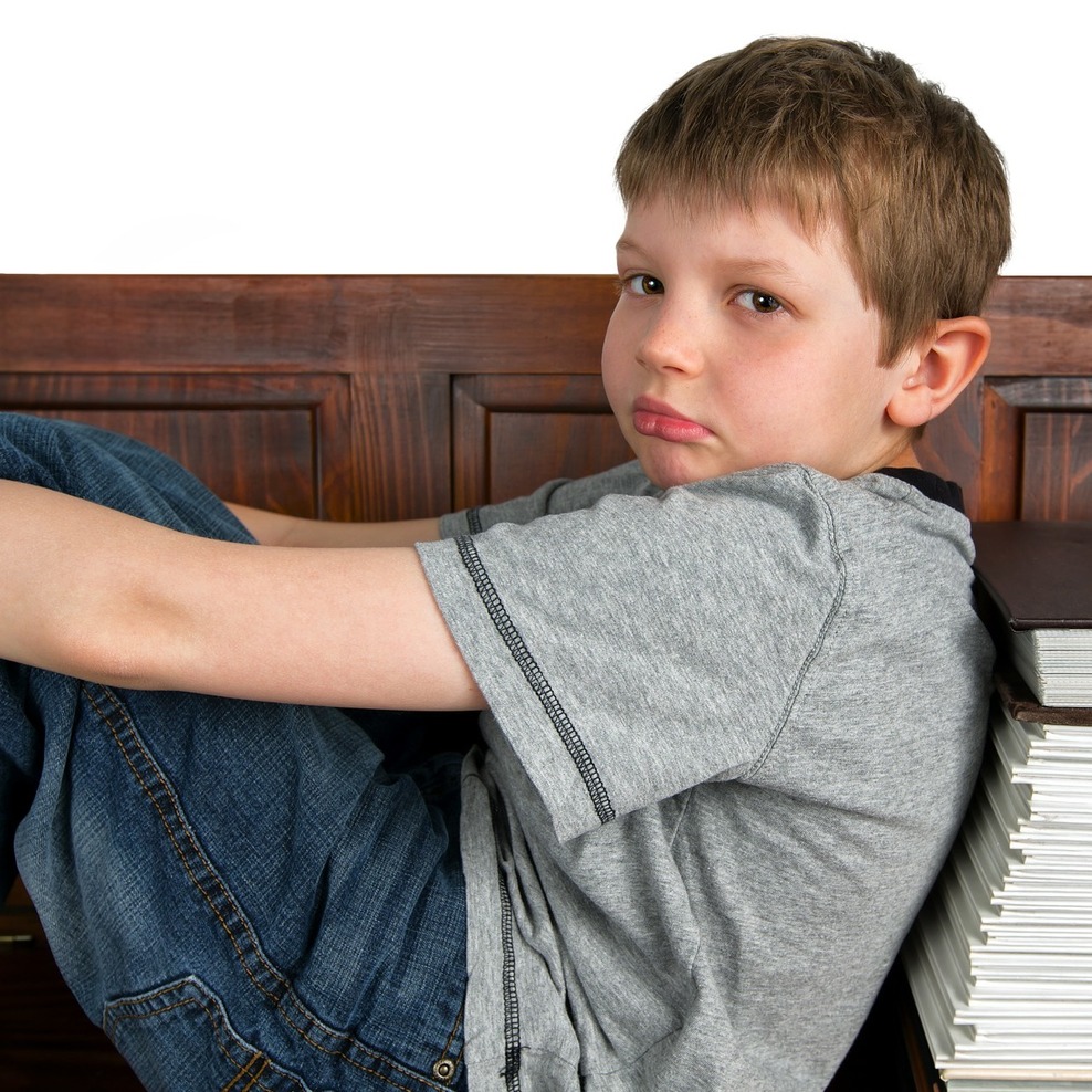 Junge auf Bank lehnt an Büchern