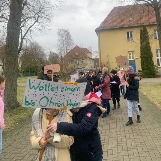 Kinderdemonstration auf dem Schulgelände mit Plakaten.
