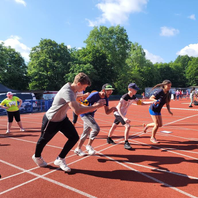 Zwei Schüler starten zum 100m Sprint mit ihren Begleitläufern