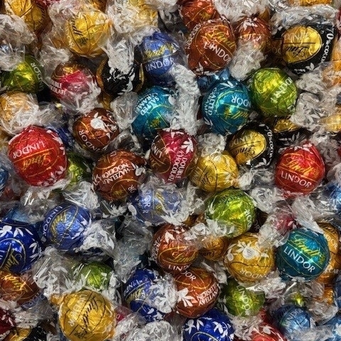 Ein Korb, gefüllt mit vielen bunten Schokokugeln.