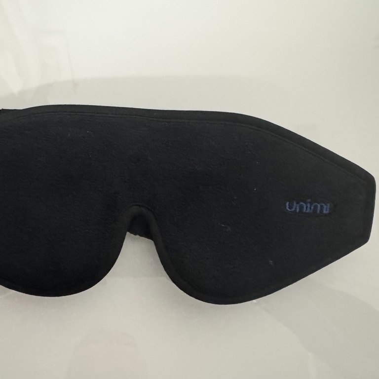 Auf dem Foto ist eine schwarze Augenbinde auf weißem Grund zu sehen.